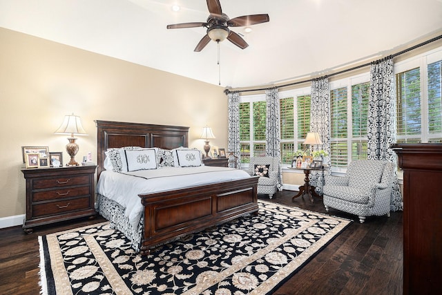 bedroom with dark wood-style floors, multiple windows, lofted ceiling, and baseboards