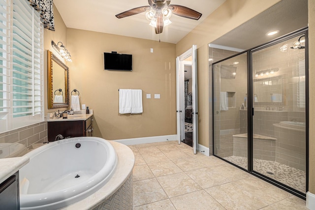 full bathroom with ceiling fan, a stall shower, vanity, a garden tub, and baseboards