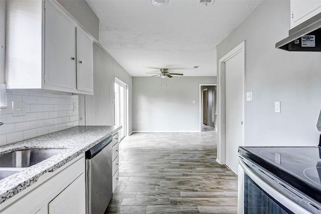 kitchen with stainless steel appliances, under cabinet range hood, ceiling fan, white cabinets, and tasteful backsplash
