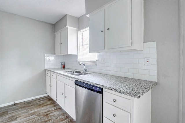 kitchen with dishwasher, a sink, light countertops, and decorative backsplash