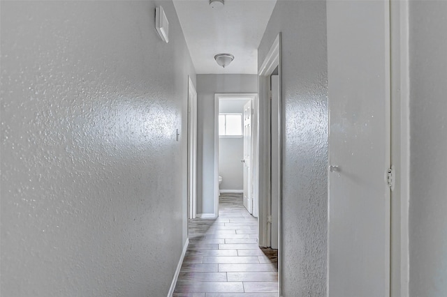 4969 E Rdg Creek Dr, Houston, TX 77053 - hallway with baseboards, a textured wall, and wood tiled floors