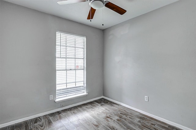 spare room with healthy amount of natural light, ceiling fan, and baseboards