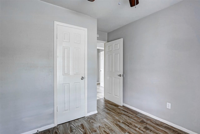 unfurnished bedroom with wood finished floors, baseboards, and ceiling fan