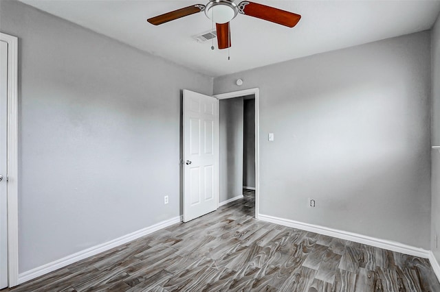 unfurnished bedroom featuring wood finished floors, baseboards, and a ceiling fan