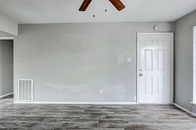 spare room with ceiling fan, wood finished floors, and baseboards