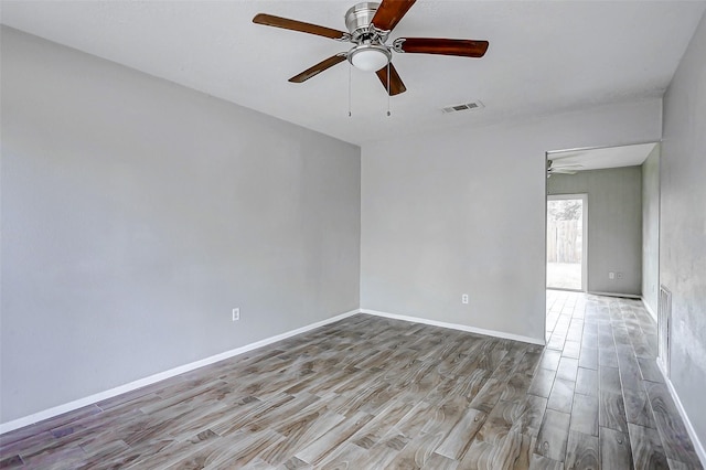 unfurnished room featuring ceiling fan, wood finished floors, and baseboards