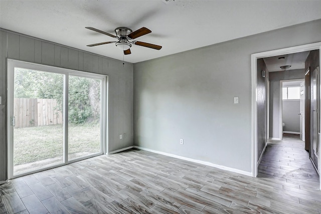 unfurnished room featuring wood tiled floors, plenty of natural light, and ceiling fan