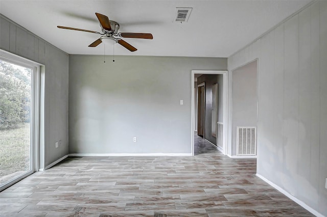 empty room with a ceiling fan, light wood-style flooring, and baseboards