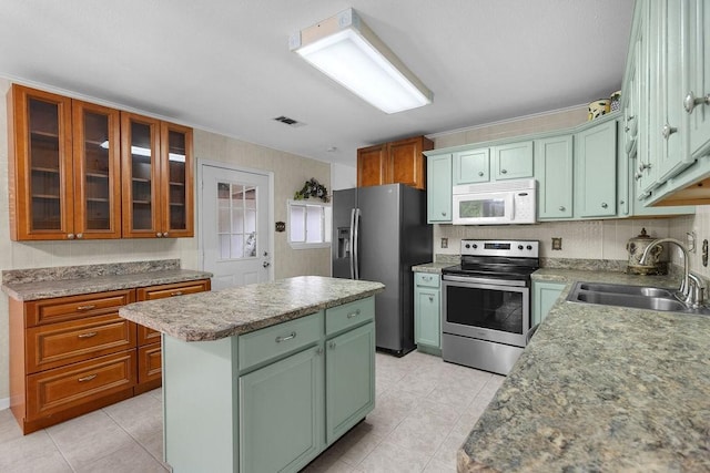 24930 Plantation Estates Ave, Porter, TX 77365 - kitchen with stainless steel appliances, green cabinets, a sink, a kitchen island, and light tile patterned floors