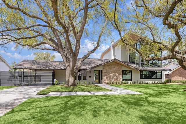 5686 Bayou Glen Rd, Houston, TX 77056 - view of front of house with concrete driveway, a front lawn, a carport, stucco siding, and brick siding