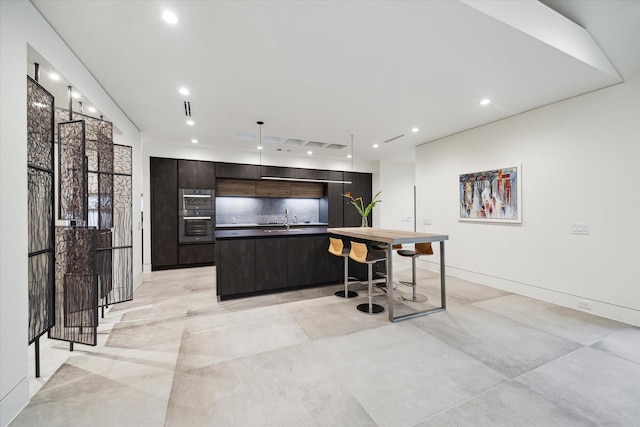 5686 Bayou Glen Rd, Houston, TX 77056 - kitchen with modern cabinets, a large island with sink, recessed lighting, a sink, and dark brown cabinets