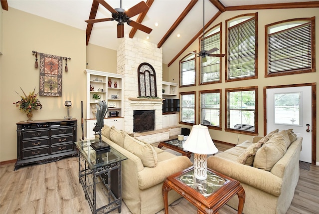 living room featuring a ceiling fan, wood finished floors, a fireplace, high vaulted ceiling, and beam ceiling