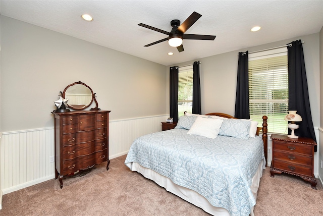 carpeted bedroom with a wainscoted wall, recessed lighting, and a ceiling fan