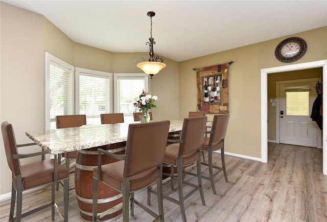 dining area featuring light wood-style flooring and baseboards