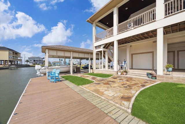 dock with a water view, a patio, and stairs