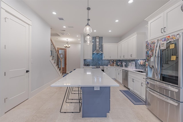 406 Fenn St Unit A, Houston, TX 77018 - kitchen featuring stainless steel appliances, wall chimney range hood, tasteful backsplash, a kitchen island, and white cabinetry