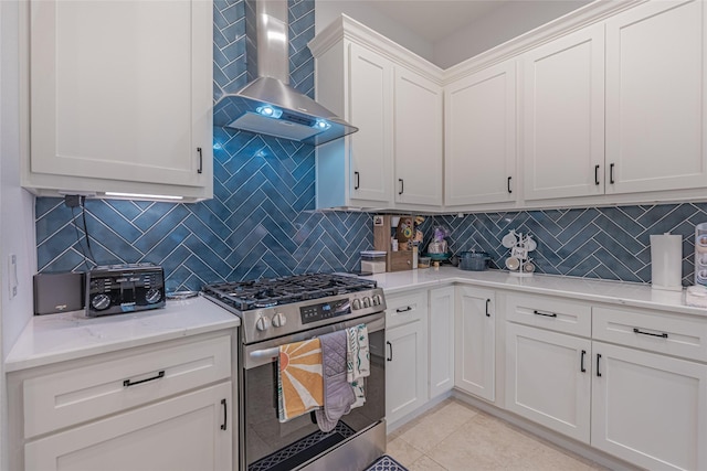406 Fenn St Unit A, Houston, TX 77018 - kitchen with stainless steel gas stove, wall chimney exhaust hood, backsplash, light tile patterned floors, and white cabinetry