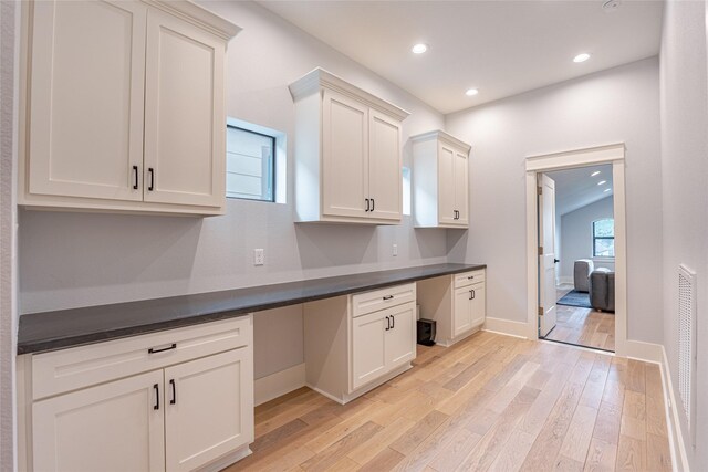 406 Fenn St Unit A, Houston, TX 77018 - kitchen with built in study area, light wood-style floors, dark countertops, baseboards, and recessed lighting