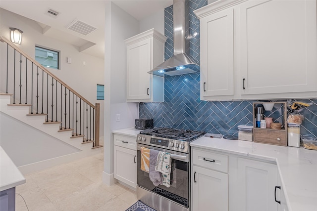 406 Fenn St Unit A, Houston, TX 77018 - kitchen with stainless steel gas range oven, wall chimney range hood, decorative backsplash, light countertops, and white cabinetry