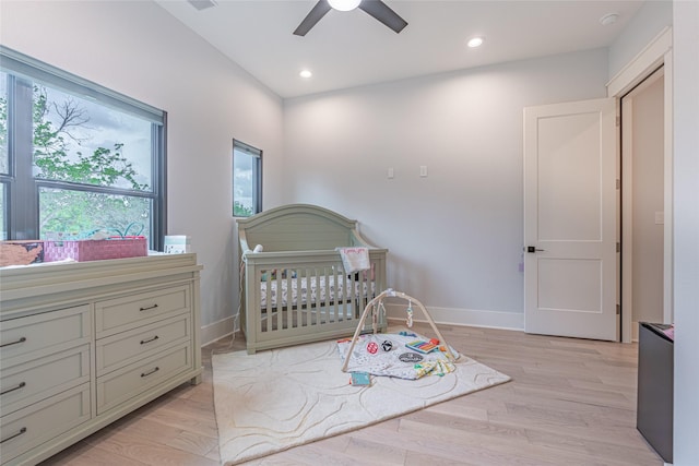 406 Fenn St Unit A, Houston, TX 77018 - bedroom with light wood-style flooring, a crib, a ceiling fan, baseboards, and recessed lighting
