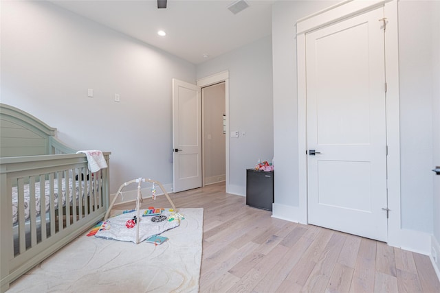 406 Fenn St Unit A, Houston, TX 77018 - bedroom featuring light wood-style floors, a crib, baseboards, and recessed lighting