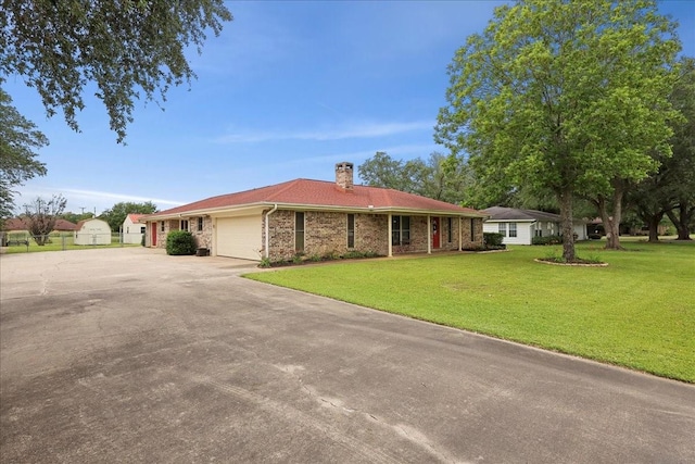 985 Sunnyside Dr, Bridge City, TX 77611 - ranch-style house featuring an attached garage, a chimney, concrete driveway, and brick siding