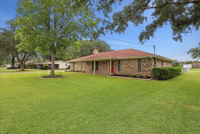 985 Sunnyside Dr, Bridge City, TX 77611 - view of front of property featuring a front lawn, a chimney, and brick siding