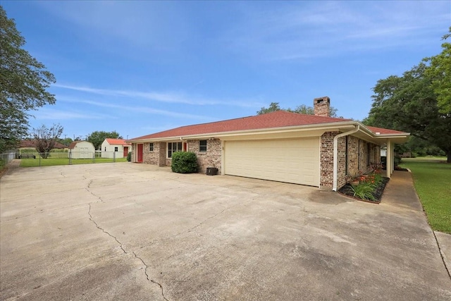 985 Sunnyside Dr, Bridge City, TX 77611 - view of front of home with a chimney, concrete driveway, fence, and an attached garage