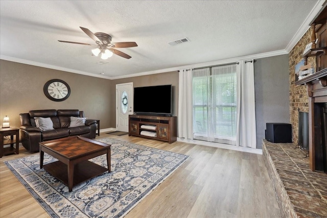 985 Sunnyside Dr, Bridge City, TX 77611 - living area with ceiling fan, wood finished floors, ornamental molding, a brick fireplace, and a textured ceiling