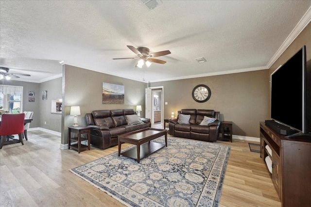 985 Sunnyside Dr, Bridge City, TX 77611 - living room featuring a ceiling fan, a textured ceiling, light wood-type flooring, baseboards, and ornamental molding