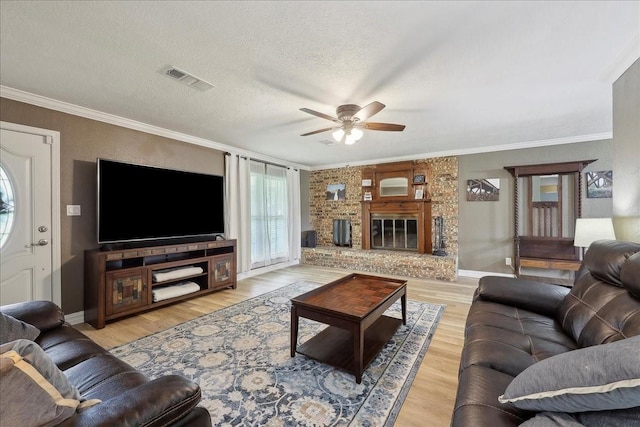 985 Sunnyside Dr, Bridge City, TX 77611 - living room featuring a ceiling fan, light wood finished floors, crown molding, baseboards, and a textured ceiling