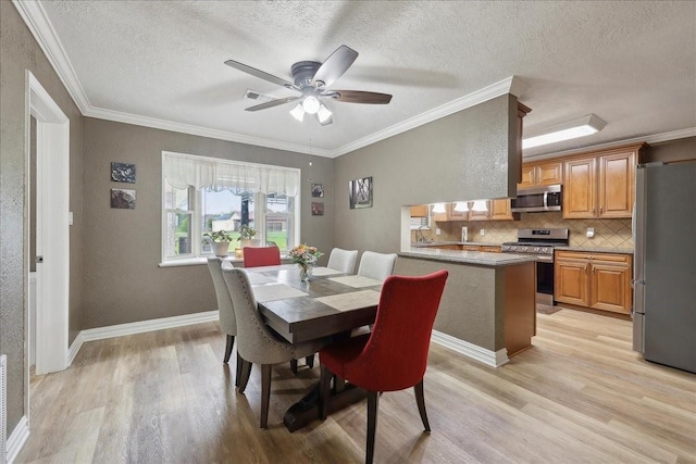 985 Sunnyside Dr, Bridge City, TX 77611 - dining room with light wood finished floors, a ceiling fan, crown molding, a textured ceiling, and baseboards