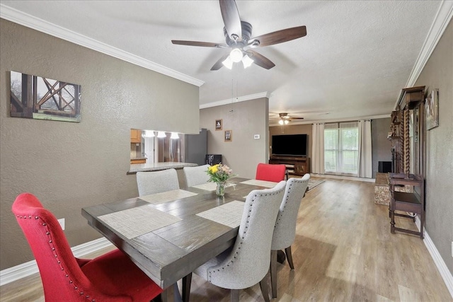 985 Sunnyside Dr, Bridge City, TX 77611 - dining room featuring ceiling fan, a textured wall, light wood-style flooring, crown molding, and baseboards