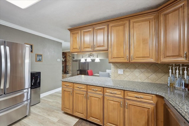 985 Sunnyside Dr, Bridge City, TX 77611 - kitchen with appliances with stainless steel finishes, brown cabinets, tasteful backsplash, light wood-style floors, and crown molding
