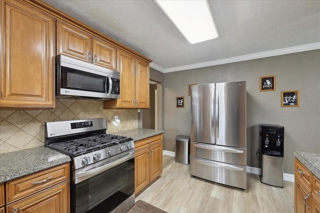 985 Sunnyside Dr, Bridge City, TX 77611 - kitchen with stainless steel appliances, light wood-type flooring, backsplash, and ornamental molding