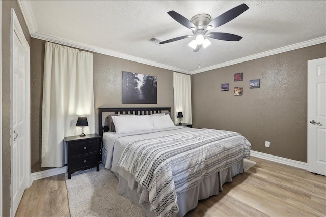 985 Sunnyside Dr, Bridge City, TX 77611 - bedroom with light wood-type flooring, a textured wall, baseboards, a textured ceiling, and ornamental molding
