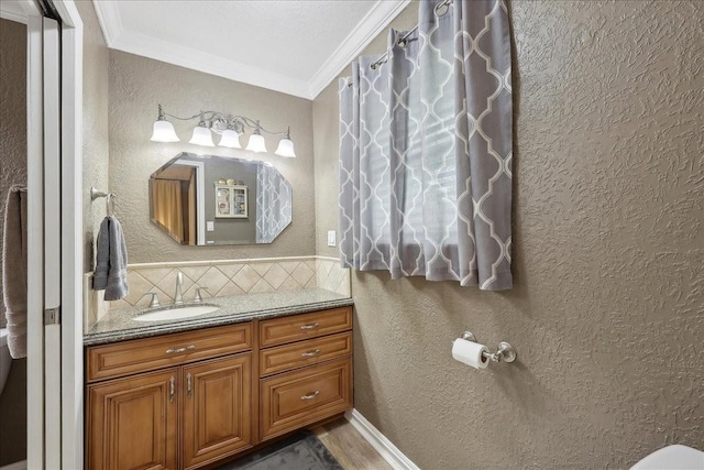 985 Sunnyside Dr, Bridge City, TX 77611 - bathroom featuring ornamental molding, a textured wall, decorative backsplash, vanity, and toilet