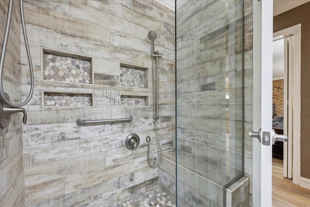 985 Sunnyside Dr, Bridge City, TX 77611 - bathroom with a tile shower and wood finished floors