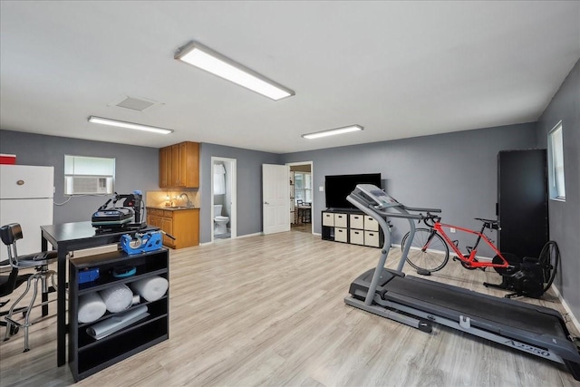 985 Sunnyside Dr, Bridge City, TX 77611 - workout area with light wood finished floors, a sink, baseboards, and cooling unit