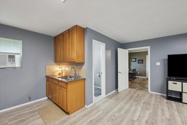 985 Sunnyside Dr, Bridge City, TX 77611 - kitchen with a sink, light wood-type flooring, brown cabinetry, and baseboards