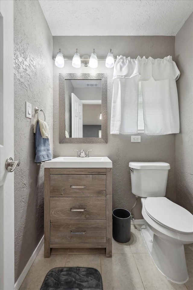 985 Sunnyside Dr, Bridge City, TX 77611 - half bath with a textured wall, vanity, toilet, tile patterned floors, and baseboards