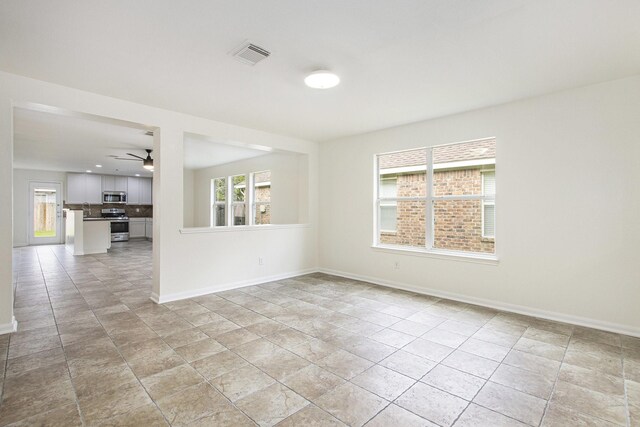 empty room featuring baseboards and a ceiling fan
