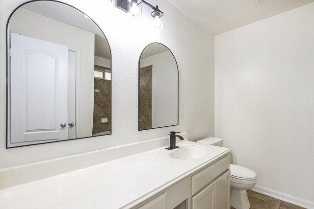 bathroom featuring toilet, vanity, tile patterned flooring, and baseboards