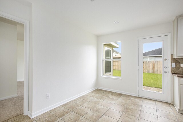 unfurnished room with baseboards and light tile patterned floors