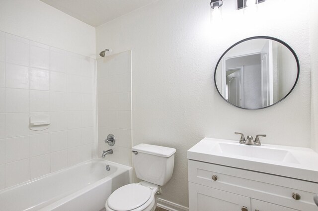 bathroom with toilet, vanity, tub / shower combination, and baseboards