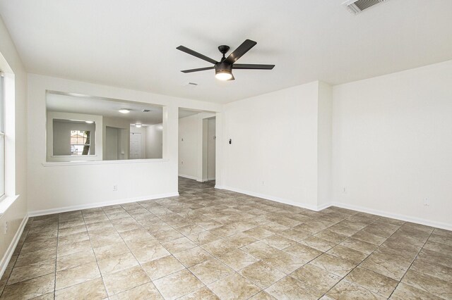 spare room with ceiling fan and baseboards