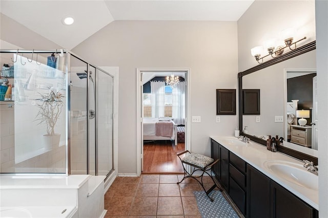 full bath with connected bathroom, vaulted ceiling, a stall shower, tile patterned floors, and double vanity