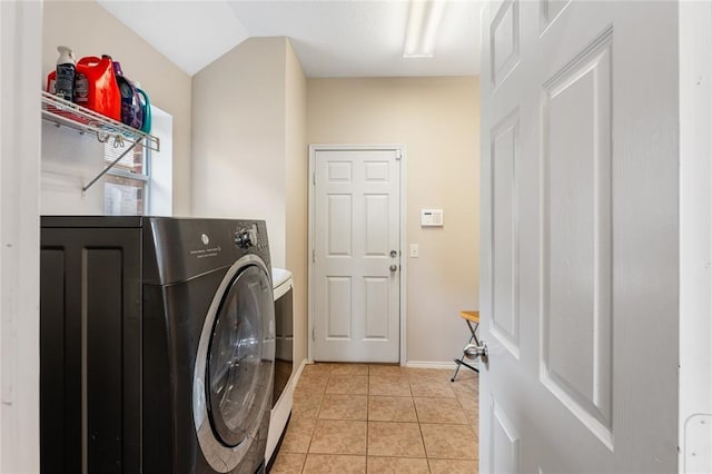 washroom featuring washer / clothes dryer, light tile patterned floors, and baseboards