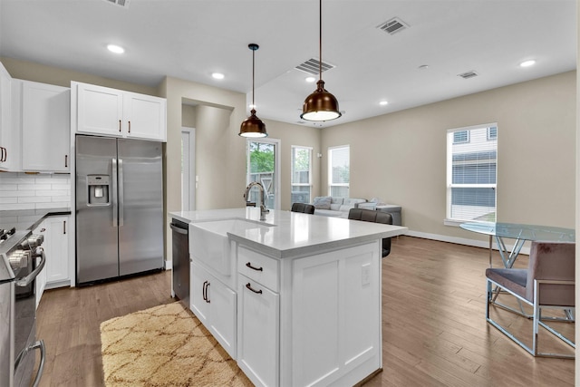 2609 Paul Quinn St, Houston, TX 77091 - kitchen with appliances with stainless steel finishes, white cabinetry, wood finished floors, open floor plan, and recessed lighting