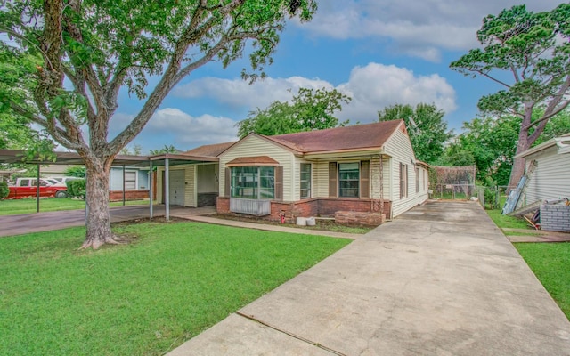 view of front of property featuring driveway, brick siding, and a carport